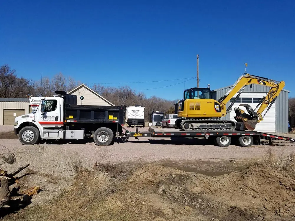 Work truck hauling heavy-duty equipment